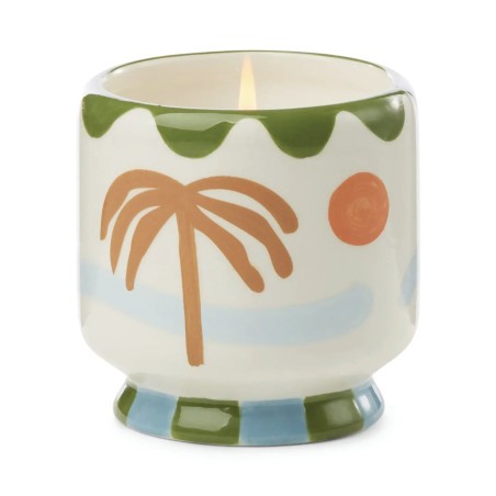 Bougie A Dopo Lush Palms Paddywax décorée de palmiers et présentée dans un pot en céramique.